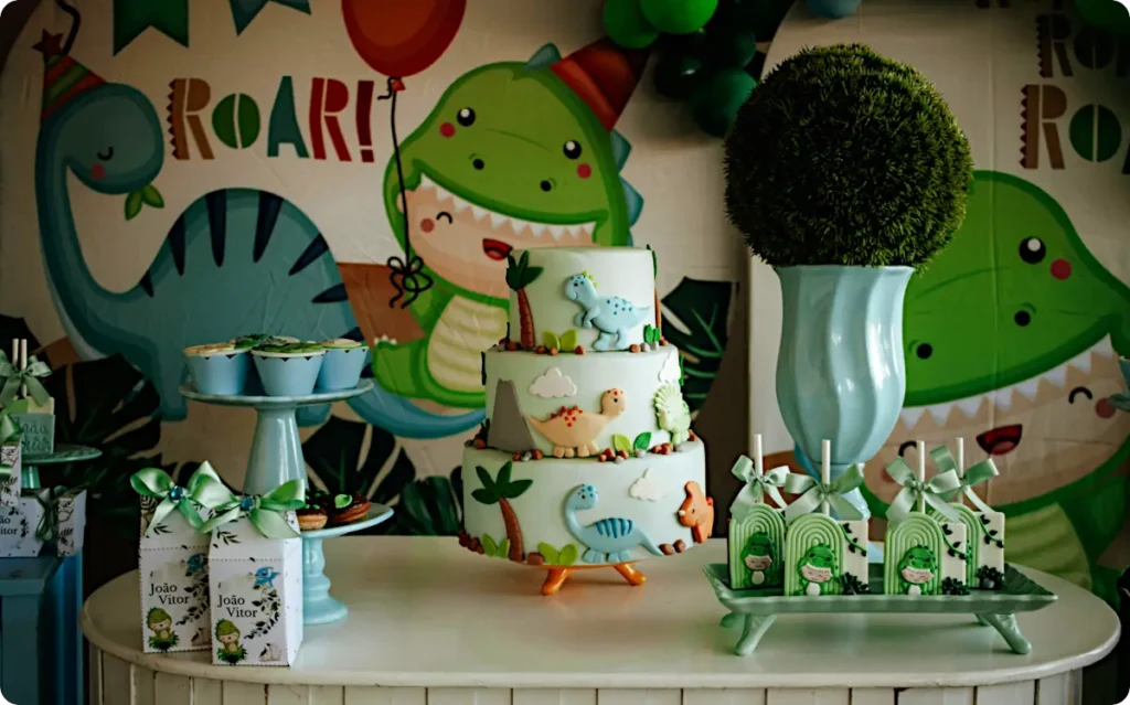 A dinosaur themed party scene with dino backdrop and table with dinosaur cake and snacks