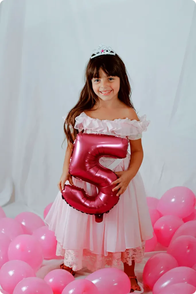 girl in princess costume with pink balloons