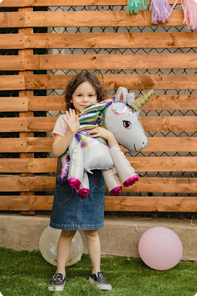 girl at unicorn party with toy