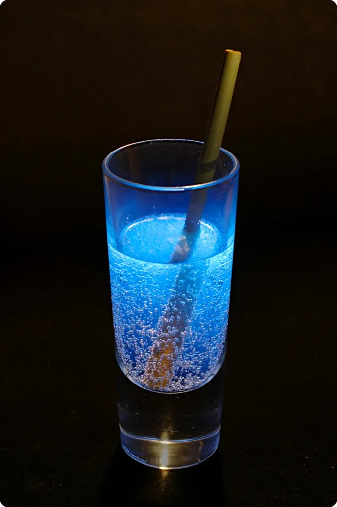 drink in glass glowing under UV light