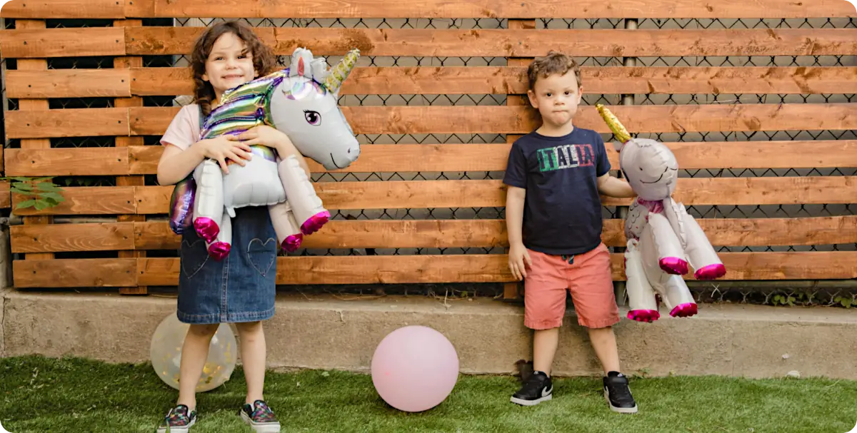 Kids at a unicorn birthday party outside with toys
