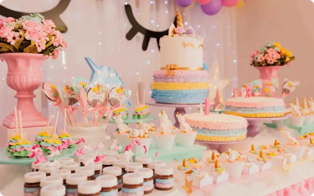 Unicorn party cake on table with snacks and decorations